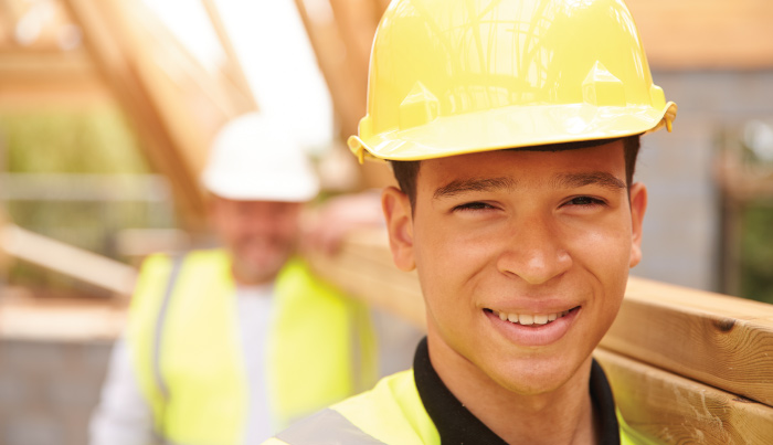 Young man working hard on a construction site and smiling